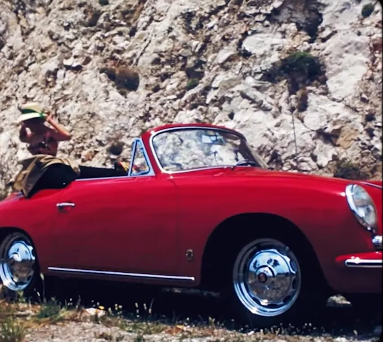 Red Porsche 356 on a rocky coast, still from the Porsche Heritage Design series